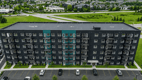 A large black building with a parking lot in front.