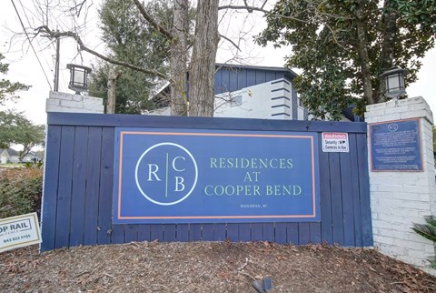A sign for Residences at Cooper Bend in front of a building.
