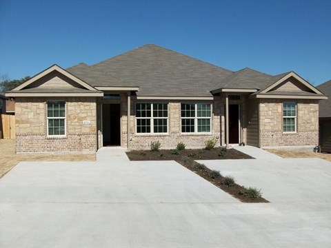 A house with a grey roof and a brown brick wall.