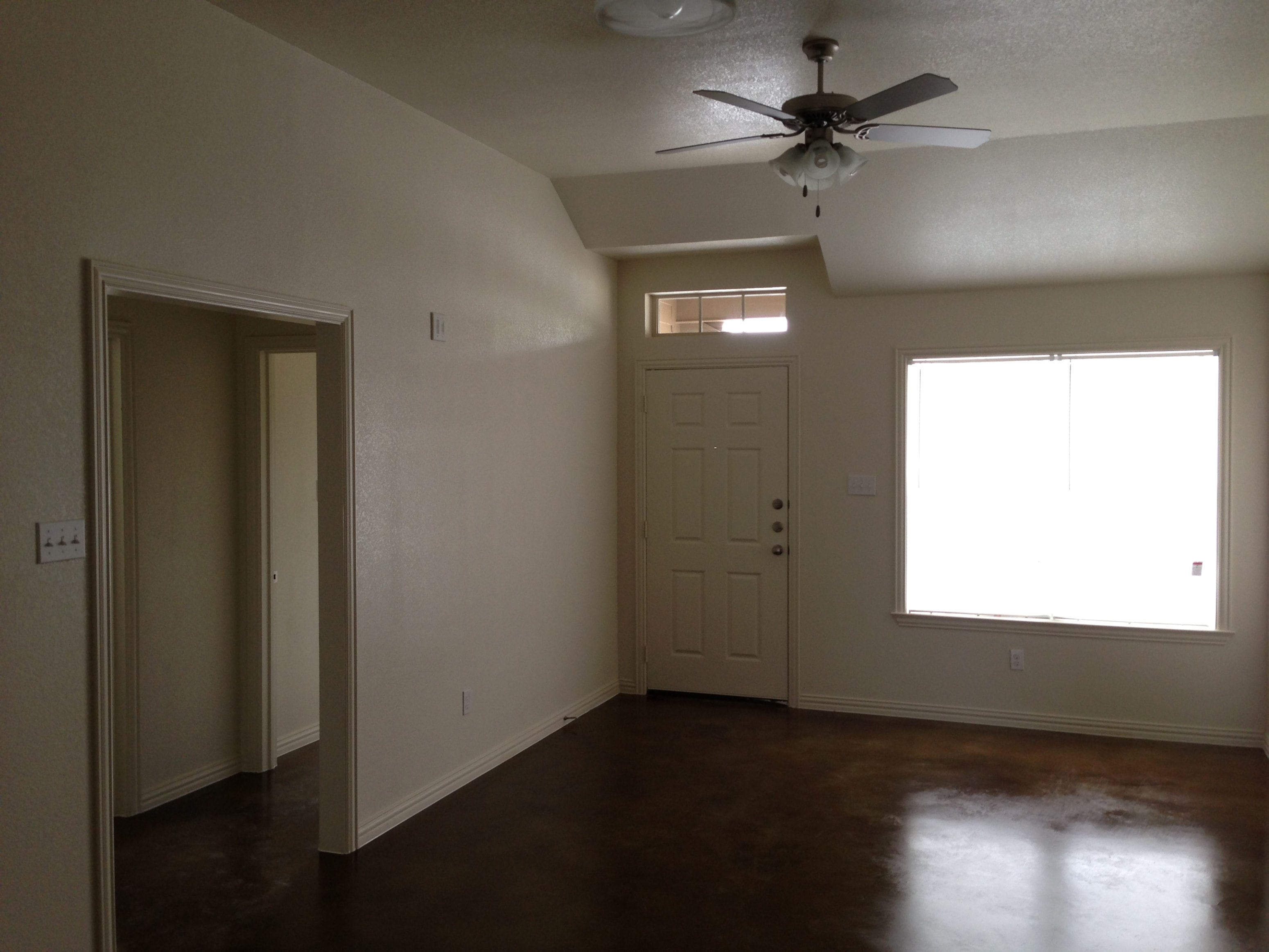A room with a ceiling fan and a window.