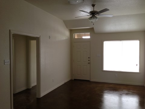 A room with a ceiling fan and a window.