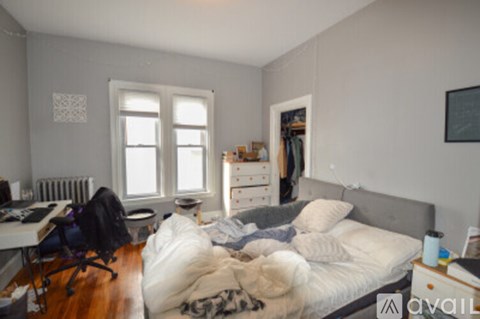 A bedroom with a bed, desk, and chair.