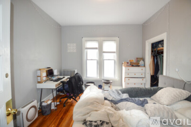 A bedroom with a bed, desk, and chair.