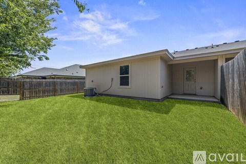 A house with a fence and a green lawn is available for rent.