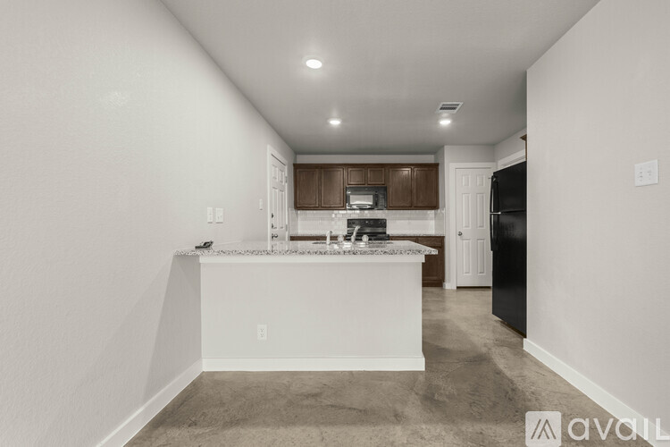 A kitchen with white cabinets and a black refrigerator.