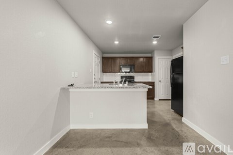 A kitchen with white cabinets and a black refrigerator.