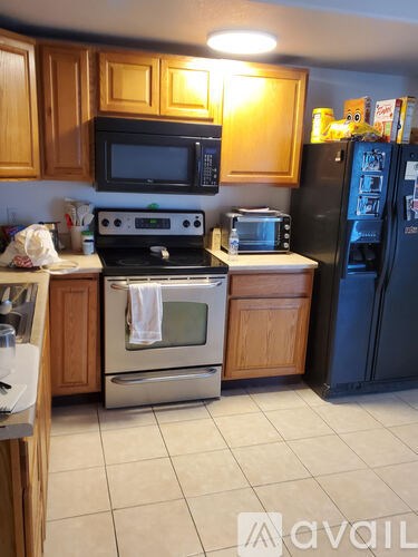 A kitchen with a black refrigerator and a black stove.