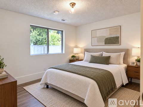 A bedroom with a large bed and a window.