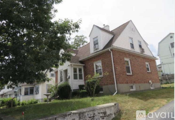 A two-story house with a red brick exterior and white trim.