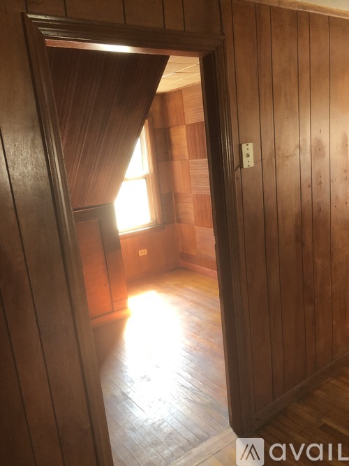 A room with wooden walls and a window.