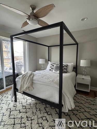 A bedroom with a four poster bed and a ceiling fan.