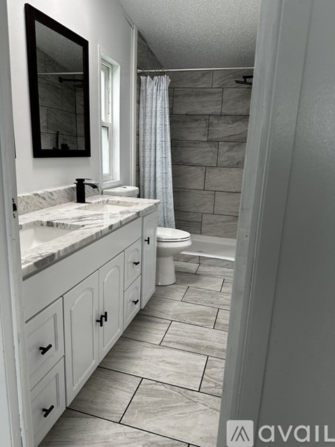 A bathroom with a marble countertop and a walk-in shower.