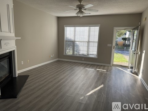 A living room with a fireplace and a ceiling fan.