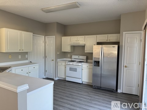 A kitchen with white cabinets and appliances.