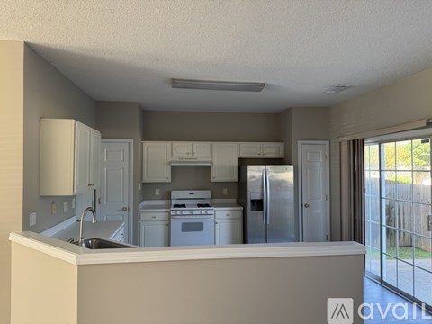 A kitchen with white appliances and a white countertop.