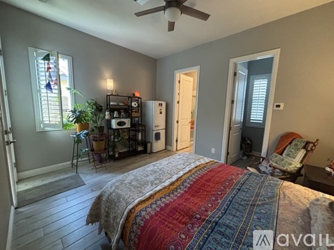 A bedroom with a large bed and a ceiling fan.