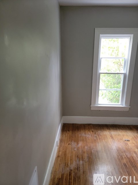 A room with a window and wooden floors is available.