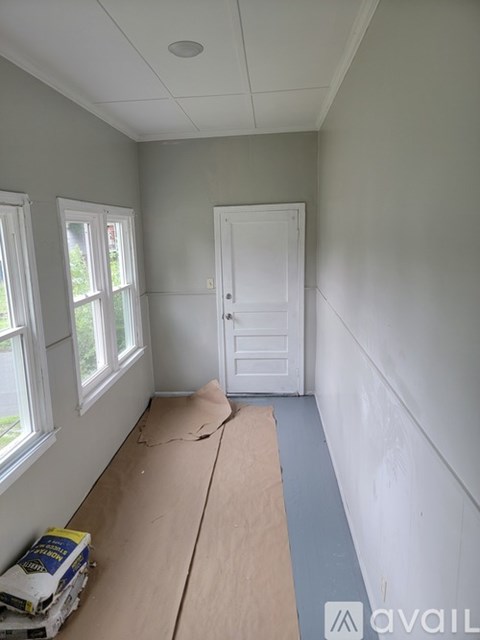 A room with a white door and windows is under construction.
