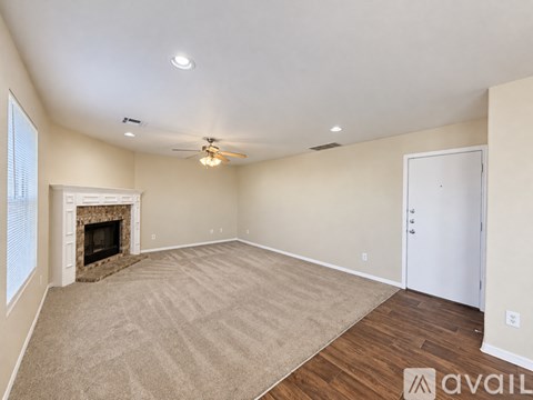 A spacious room with a fireplace and carpeted floor.