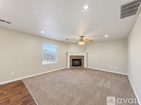 A living room with a fireplace and a ceiling fan.