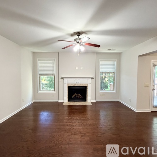 A living room with a fireplace and a ceiling fan.