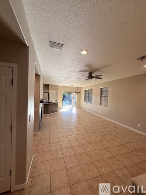 A spacious room with a fan and a door on the left side.