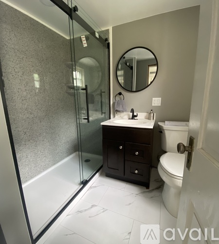 A bathroom with a sink, toilet, and glass shower stall.