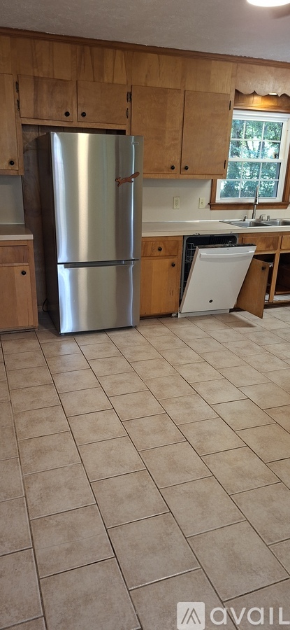 A kitchen with a refrigerator and a sink.