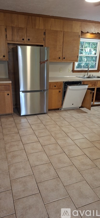 A kitchen with a refrigerator and a sink.