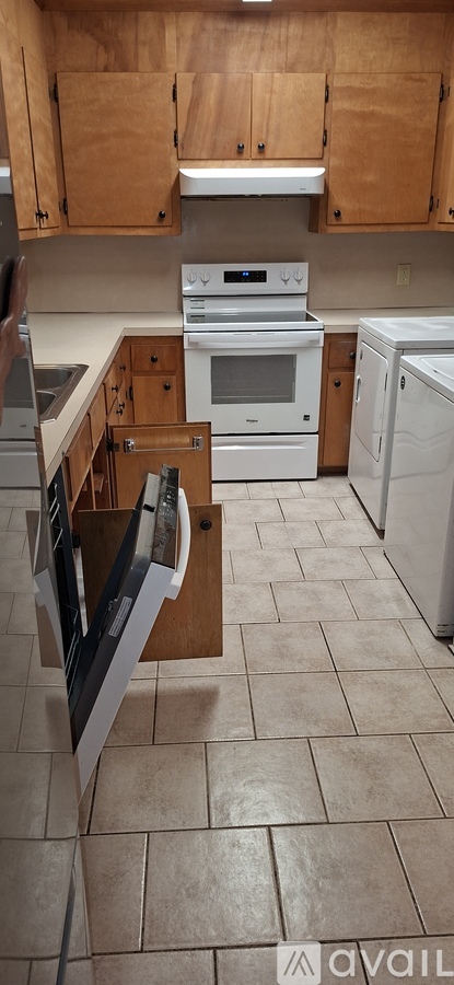 A kitchen with a white oven and wooden cabinets.