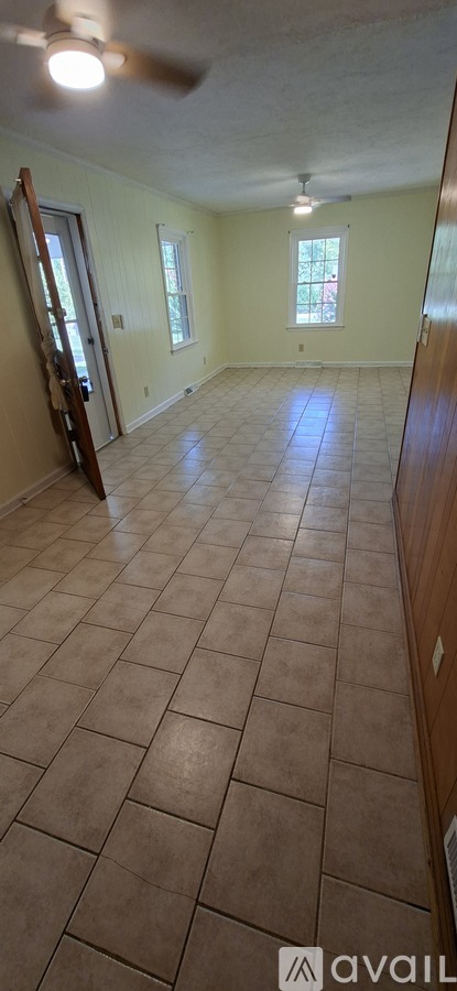 A room with a ceiling fan and tile flooring.