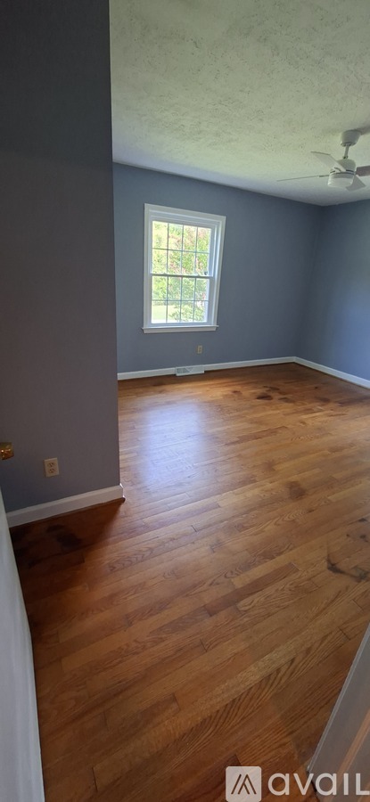 A room with wooden flooring and a window.