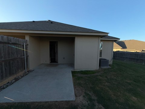 A house with a concrete driveway and a brown fence.