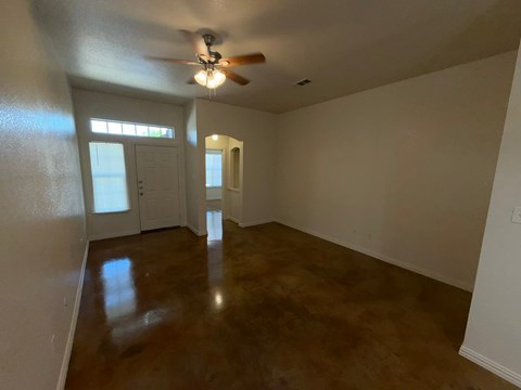 A room with a ceiling fan and a door.