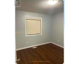 A room with a wooden floor and a window.