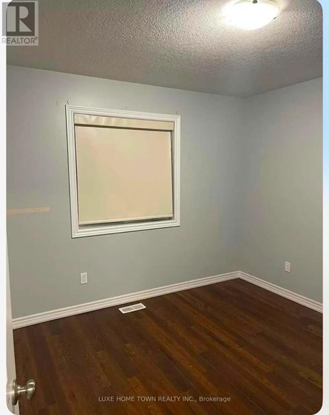 A room with a wooden floor and a window.
