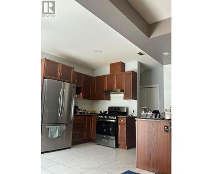 A kitchen with a refrigerator, oven, and cabinets.