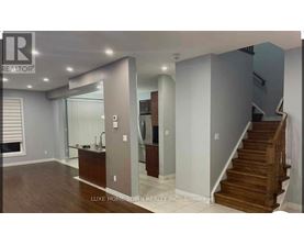 A spacious room with a staircase leading to the upper floor.