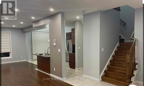 A spacious room with a staircase leading to the upper floor.