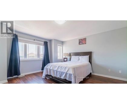 A bedroom with a bed, nightstand, and window with curtains.