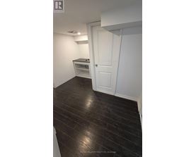 A room with a white door and a wooden floor.