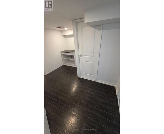 A room with a white door and a wooden floor.