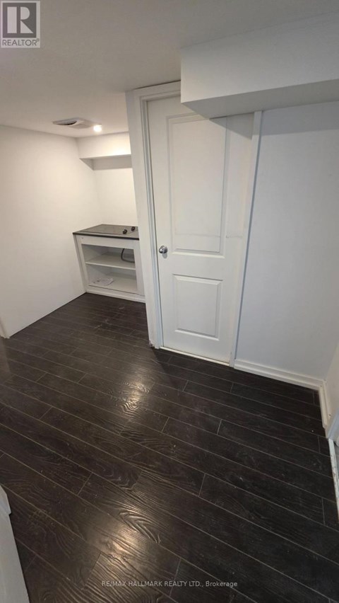 A room with a white door and a wooden floor.