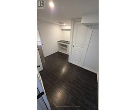 A room with a white door and a wooden floor.