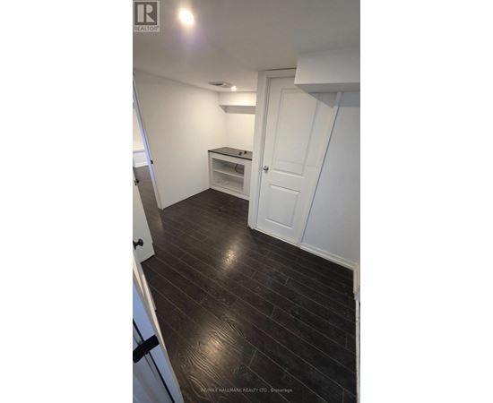 A room with a white door and a wooden floor.