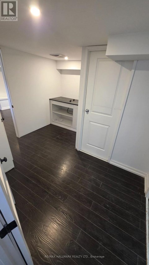 A room with a white door and a wooden floor.