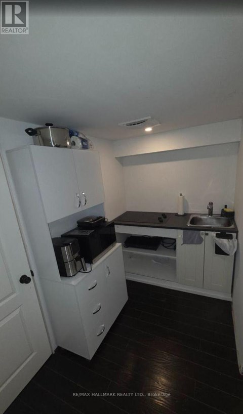 A small kitchen with white cabinets and a sink.
