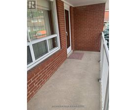 A balcony with a white railing and a brick wall.
