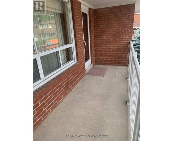 A balcony with a white railing and a brick wall.