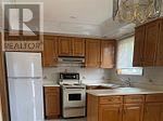 A kitchen with wooden cabinets and a white refrigerator.